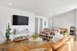Living room with light wood-style floors and recessed lighting