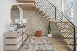 Staircase with wood finished floors and a high ceiling