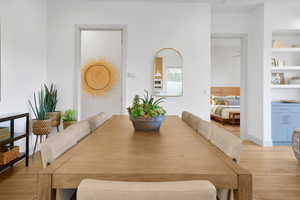 Dining area with light wood-type flooring and built in features