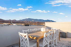 View of patio with outdoor dining space and a deck with mountain view