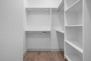 Walk in closet with light wood-style floors