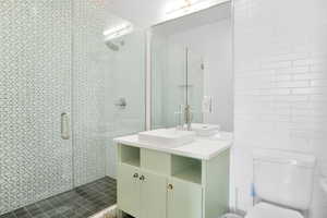 Bathroom featuring vanity, tile walls, and a stall shower