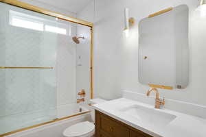 Full bathroom with vanity and combined bath / shower with glass door