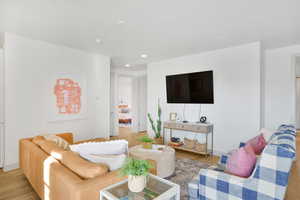 Living room with light wood-style floors and recessed lighting