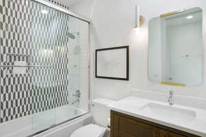 Bathroom with vanity and combined bath / shower with glass door