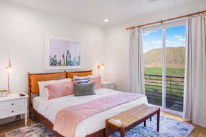 Bedroom with wood finished floors, access to exterior, a mountain view, recessed lighting, and view of golf course