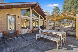 View of patio / terrace featuring a pergola, french doors, an outdoor living / dining area, and entry steps