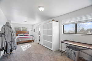 Downstairs: beddroom featuring light carpet and baseboards