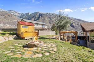 View of yard featuring a pergola, an outdoor fire pit, sauna and cold plunge, a mountain view, and a patio area