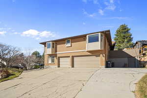 View of front facade with a garage, driveway, and brick siding