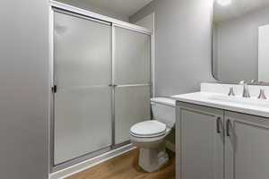 Full bathroom featuring vanity, light wood-style floors, and a stall shower