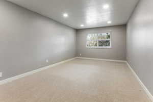 Spare room featuring light carpet and recessed lighting