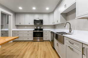 Kitchen with stainless steel appliances, light wood finished floors, recessed lighting, and wood counters