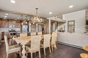 Dining room with dark wood finished floors and suspended lighting