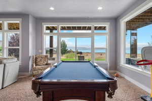 Playroom featuring a water view, billiards, carpet, healthy amount of natural light, and recessed lighting