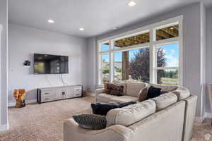 Living area featuring light carpet, recessed lighting, and a textured ceiling