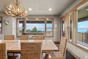 Dining room with a chandelier, a textured ceiling, and wood finished floors