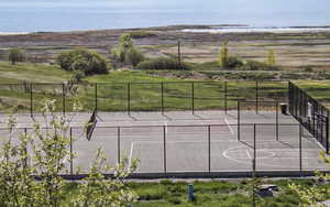View of sport court with a water view and community basketball court