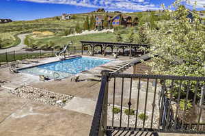 Community pool with a water slide and a patio