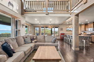 Living area with recessed lighting, dark wood-style floors, and a high ceiling