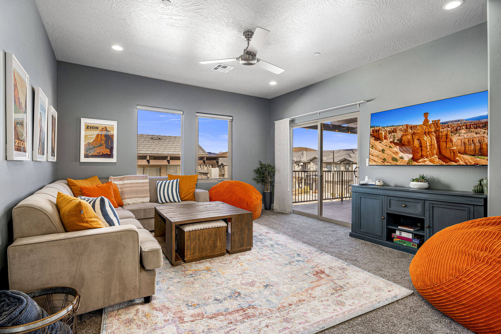 Carpeted living room featuring ceiling fan, recessed lighting, and a textured ceiling