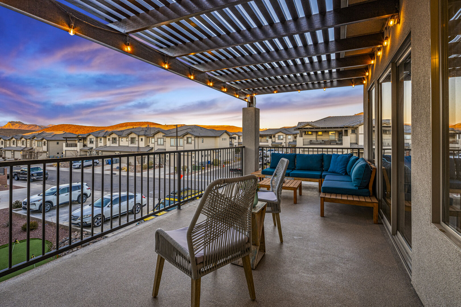 Balcony at dusk featuring a residential view, an outdoor living space, and a pergola