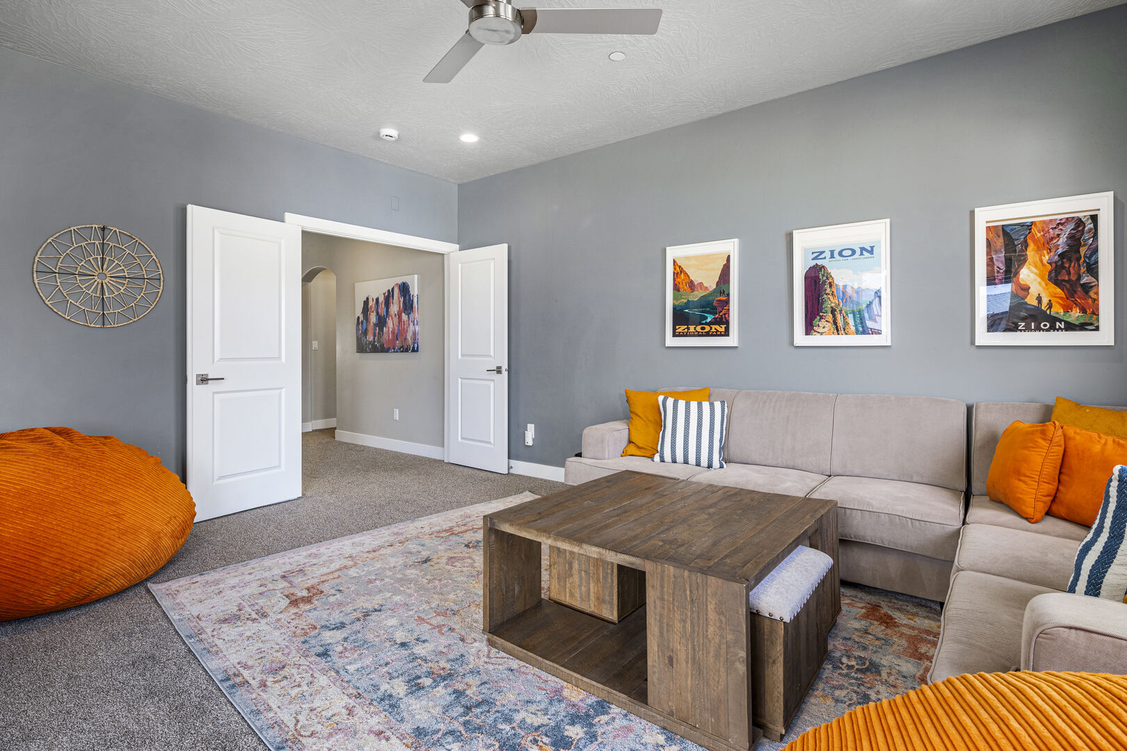 Carpeted living room featuring ceiling fan and baseboards