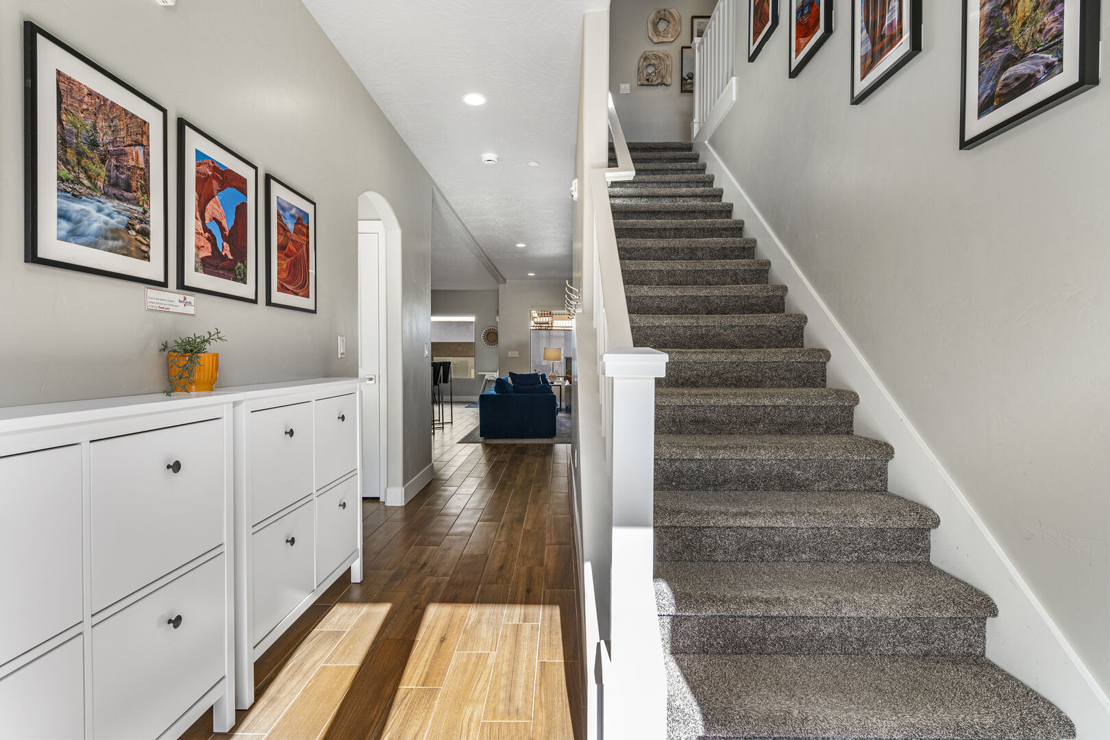 Stairway featuring arched walkways, wood finished floors, a fireplace, and recessed lighting