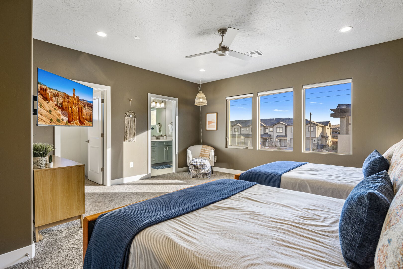 Bedroom with light carpet, ceiling fan, recessed lighting, ensuite bath, and a textured ceiling