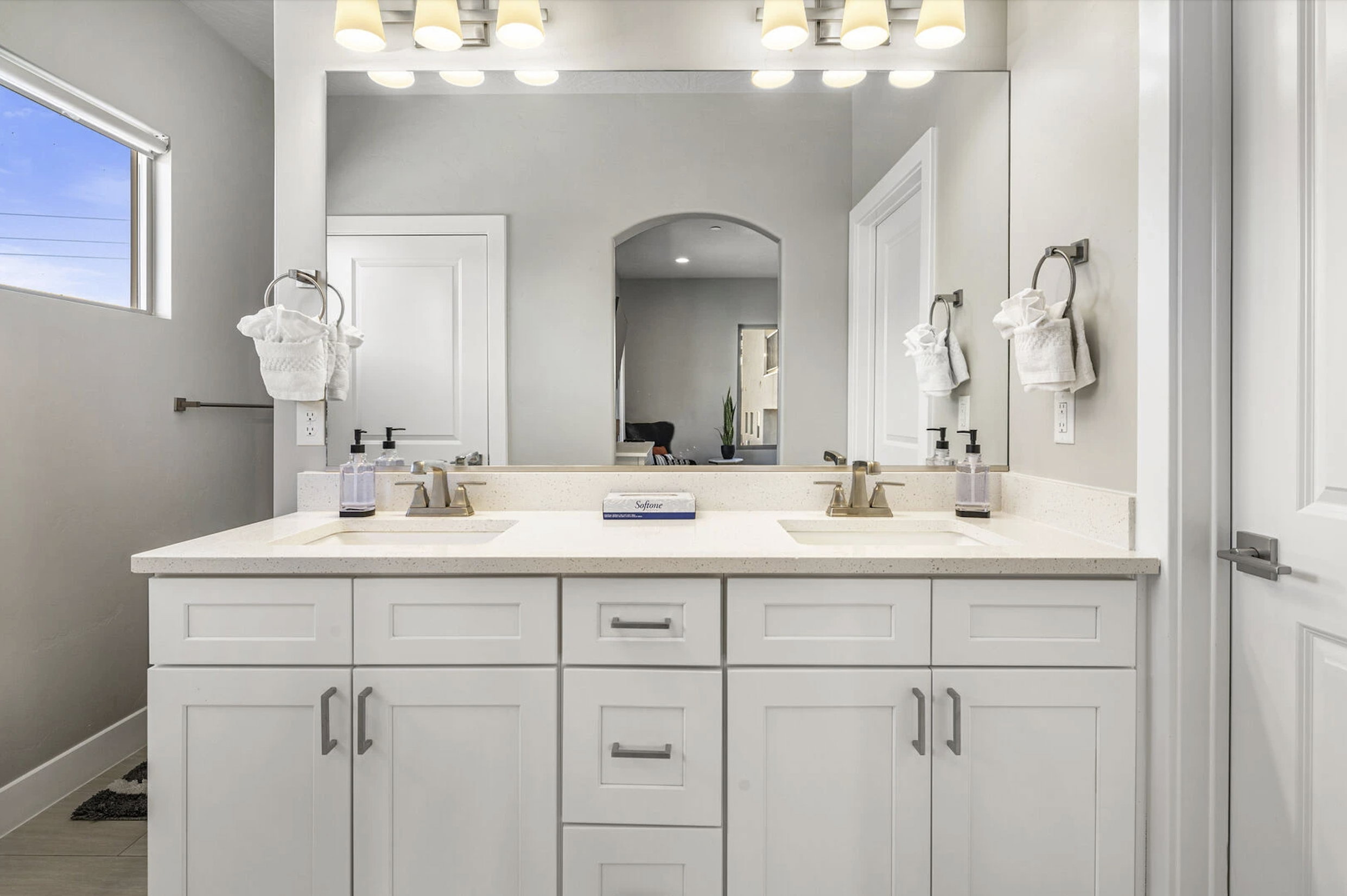 Full bathroom featuring double vanity and baseboards