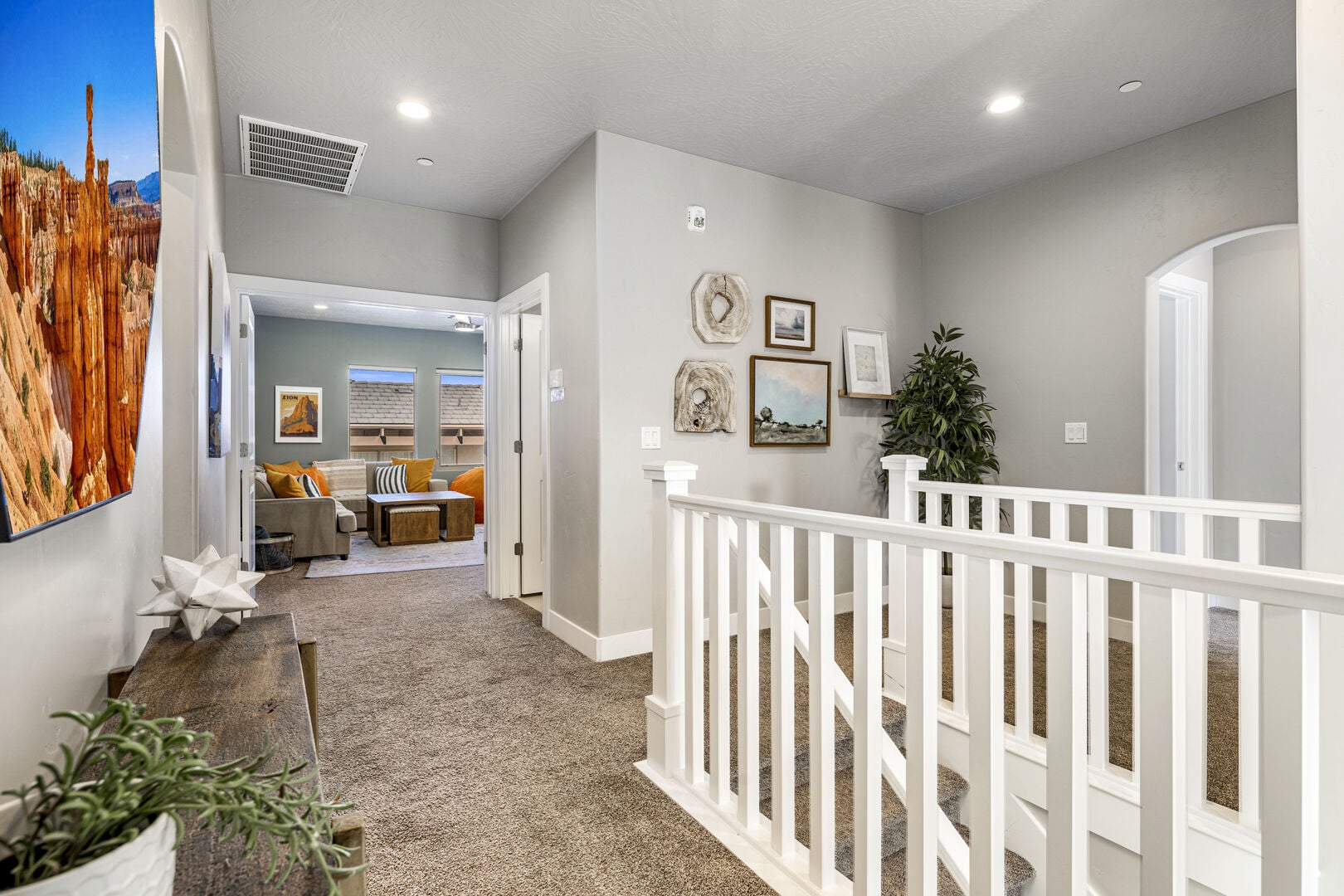 Hall with carpet floors, arched walkways, recessed lighting, and an upstairs landing