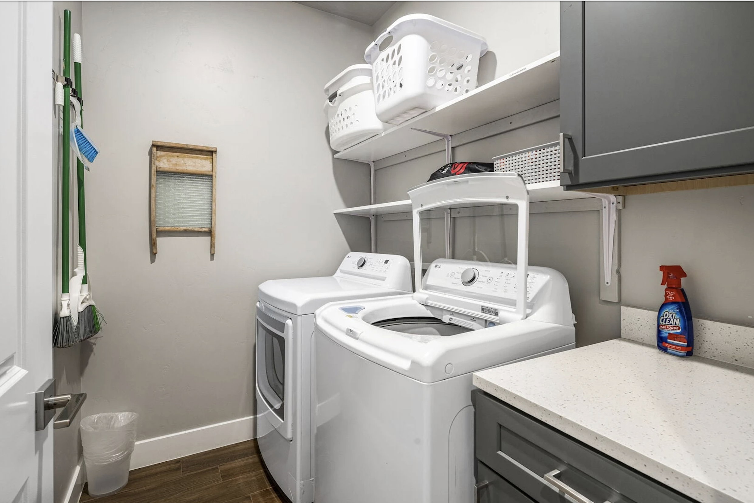 Laundry area featuring cabinet space, washer and clothes dryer, and dark wood-style flooring