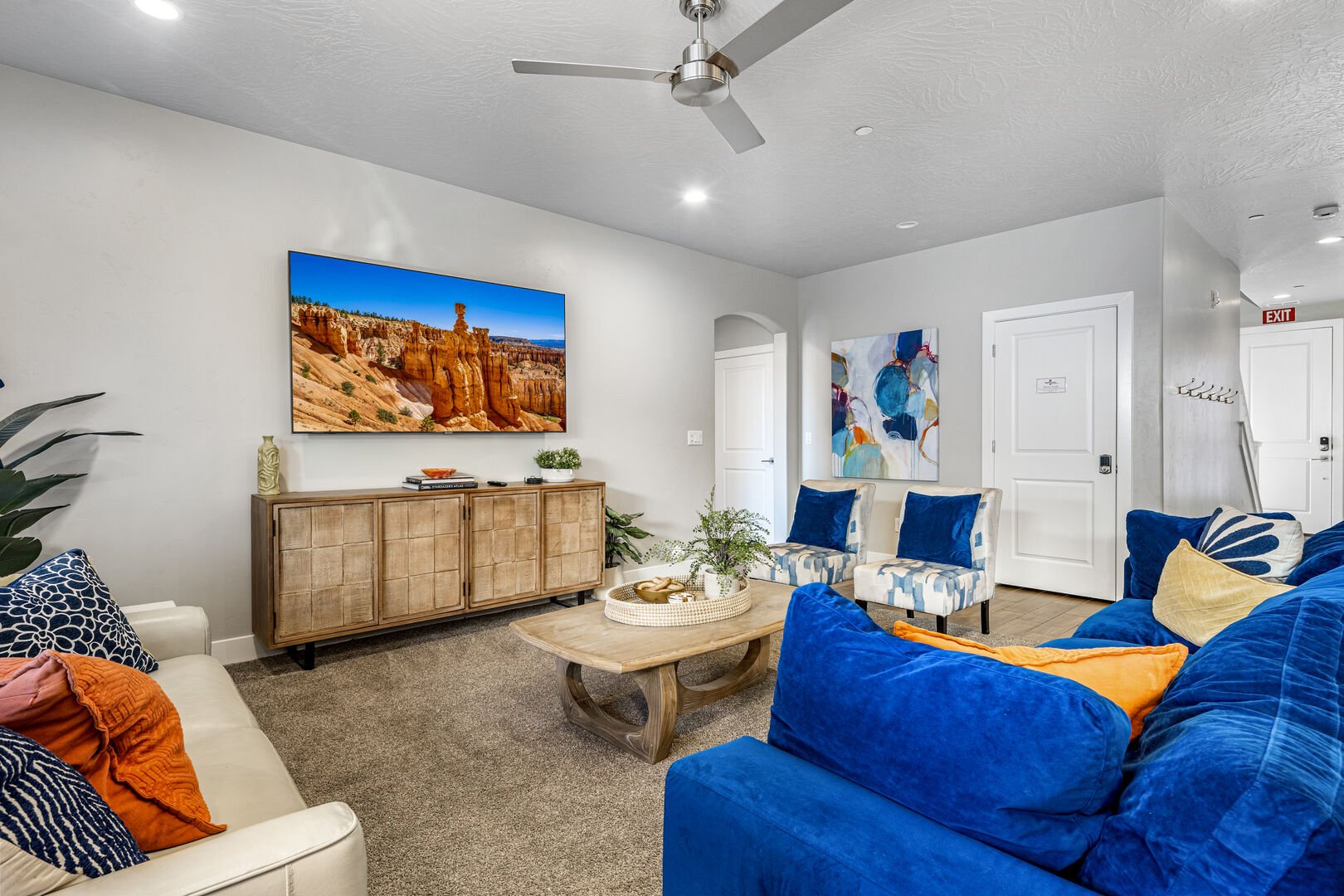 Carpeted living room featuring arched walkways, ceiling fan, and recessed lighting