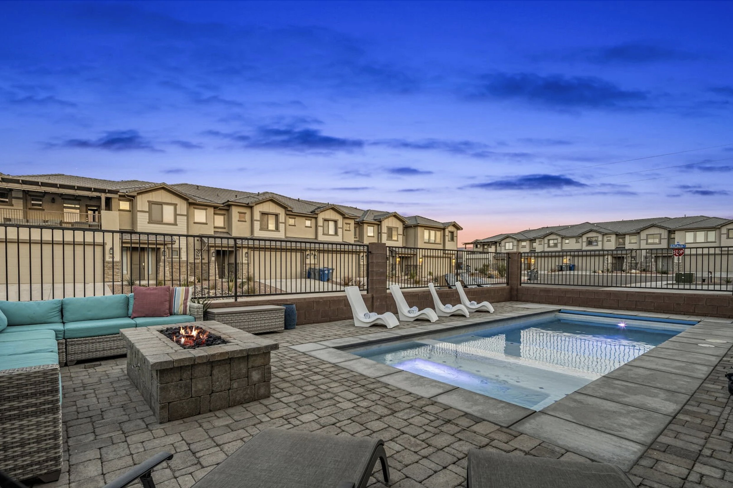 Integrated pool / spa featuring a residential view, a patio, and an outdoor living space with a fire pit