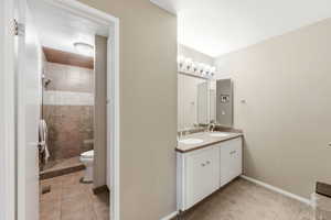 Bathroom with double vanity, a stall shower, and light colored carpet