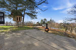 View of patio with a fire pit and a trampoline