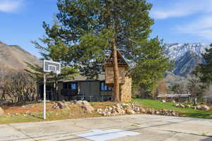 View of sport court featuring a mountain view and basketball hoop