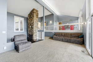 Living area featuring lofted ceiling and carpet floors