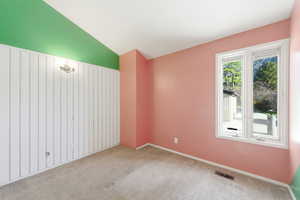 Spare room with vaulted ceiling and carpet floors
