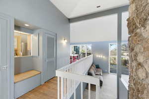 Corridor with vaulted ceiling, recessed lighting, and light wood-style floors