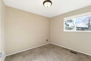 Spare room with baseboards and light carpet
