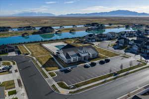 Aerial perspective of clubhouse featuring outdoor pool. Man-made lakes offer a beautiful view and walking path nearby.