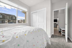 Carpeted bedroom with view of a closet