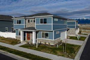 View of front of house featuring stone siding, a garage, and concrete driveway