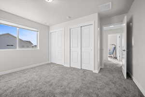 Bedroom featuring carpet, multiple closets, and a textured ceiling