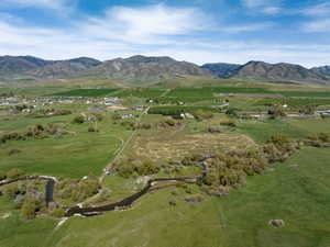 Expansive rural landscape featuring a winding river, mature trees, and mountainous terrain