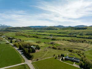 Expansive aerial view showcasing a large residential property amidst verdant fields and rolling hills