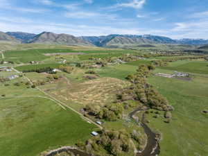 Expansive rural landscape featuring lush green fields and scattered trees