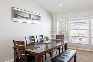 Dining room with lofted ceiling, light carpet, recessed lighting, and a mountain view