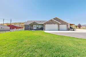 Ranch-style home featuring a garage, driveway, and brick siding